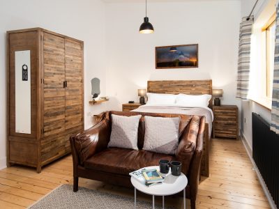 Reiver Studio – Image of bed, sofa, coffee table and wardrobe in a driftwood theme