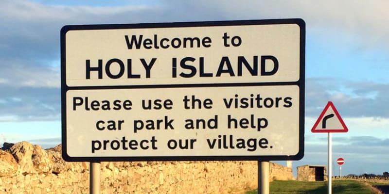 A sign at the entrance to Holy Island welcoming visitors.